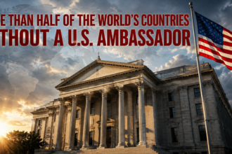 Bold red headline over a government building and US flag: 'More than half of the world's countries without a U.S. ambassador' conveying a diplomatic shortage claim